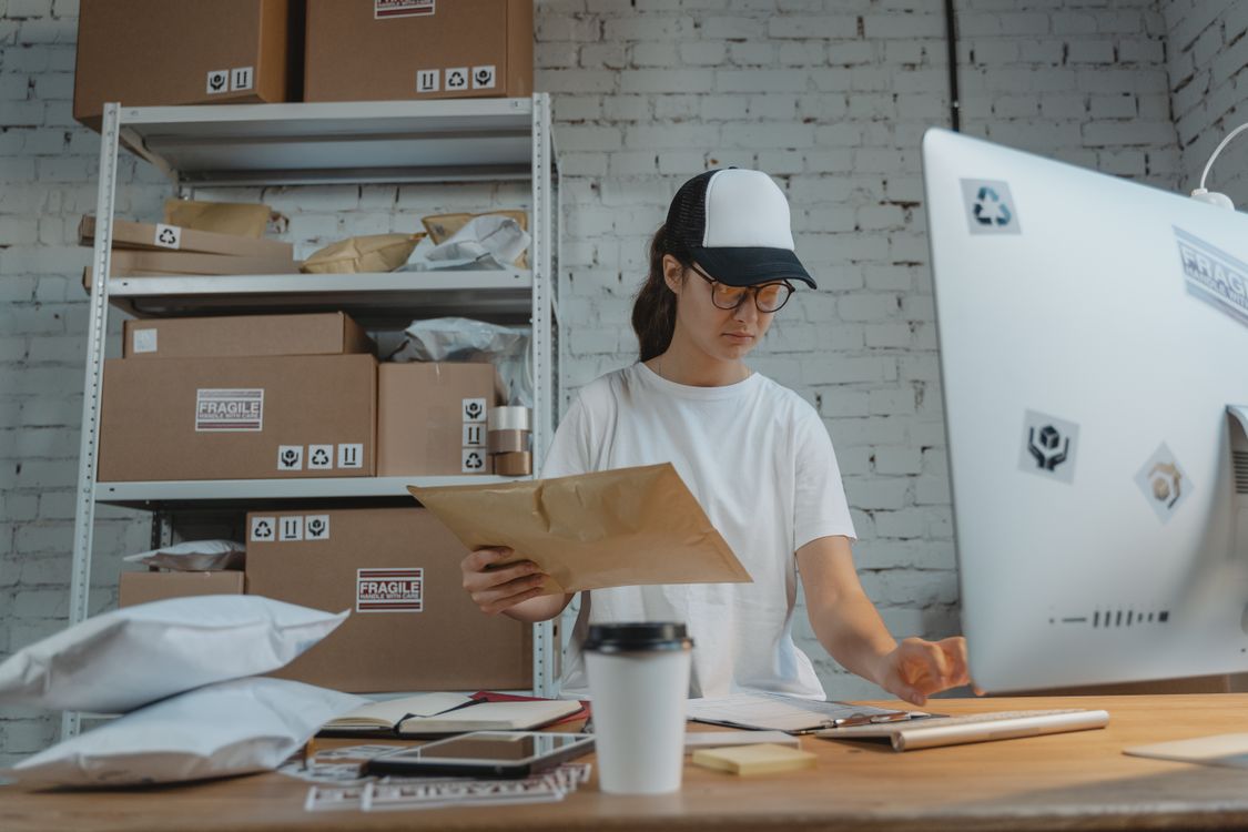 An operations professional reviewing shipping paperwork at a workstation